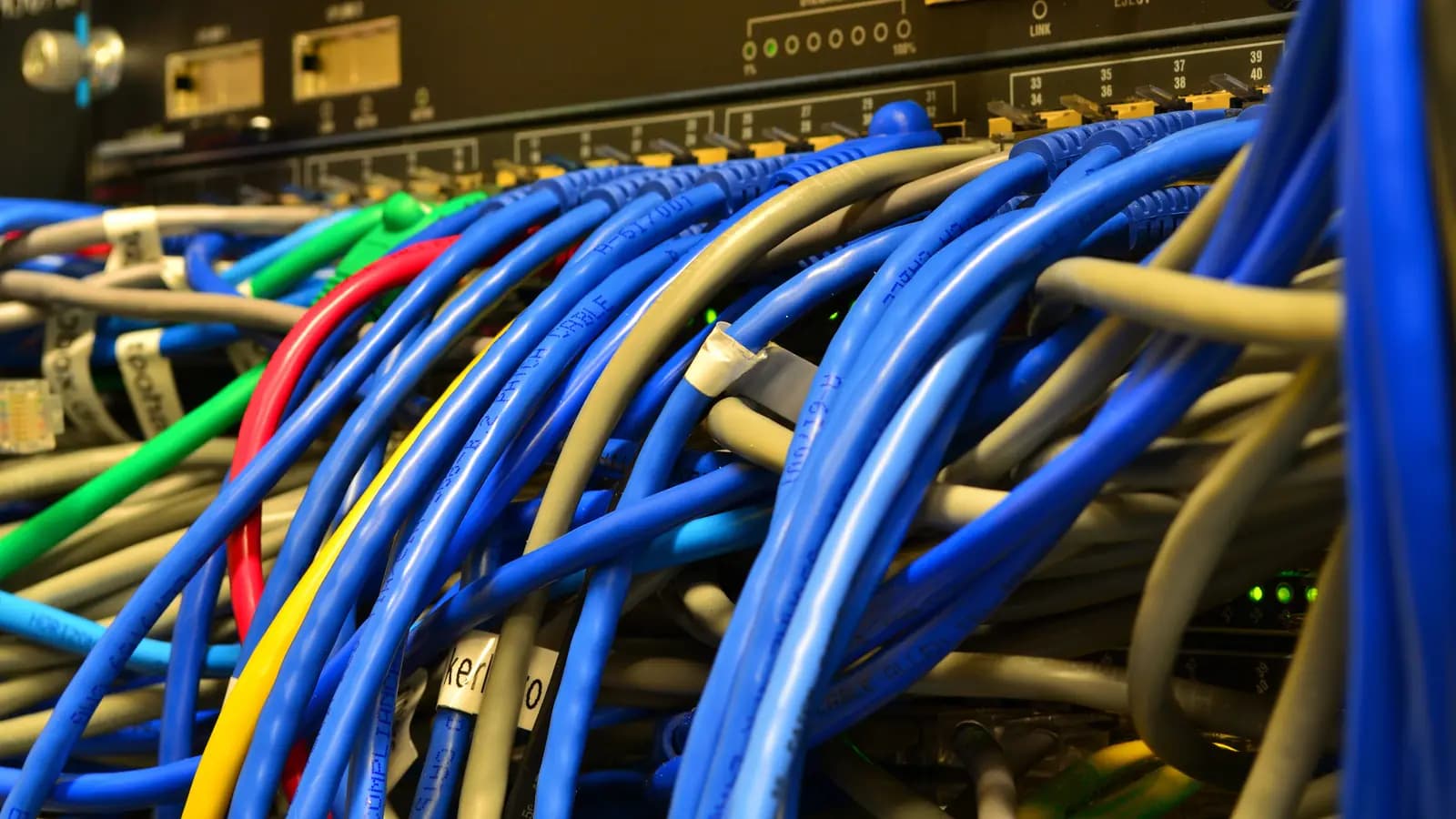 Dezenas de cabos de rede coloridos conectados às portas de um switch Ethernet em rack