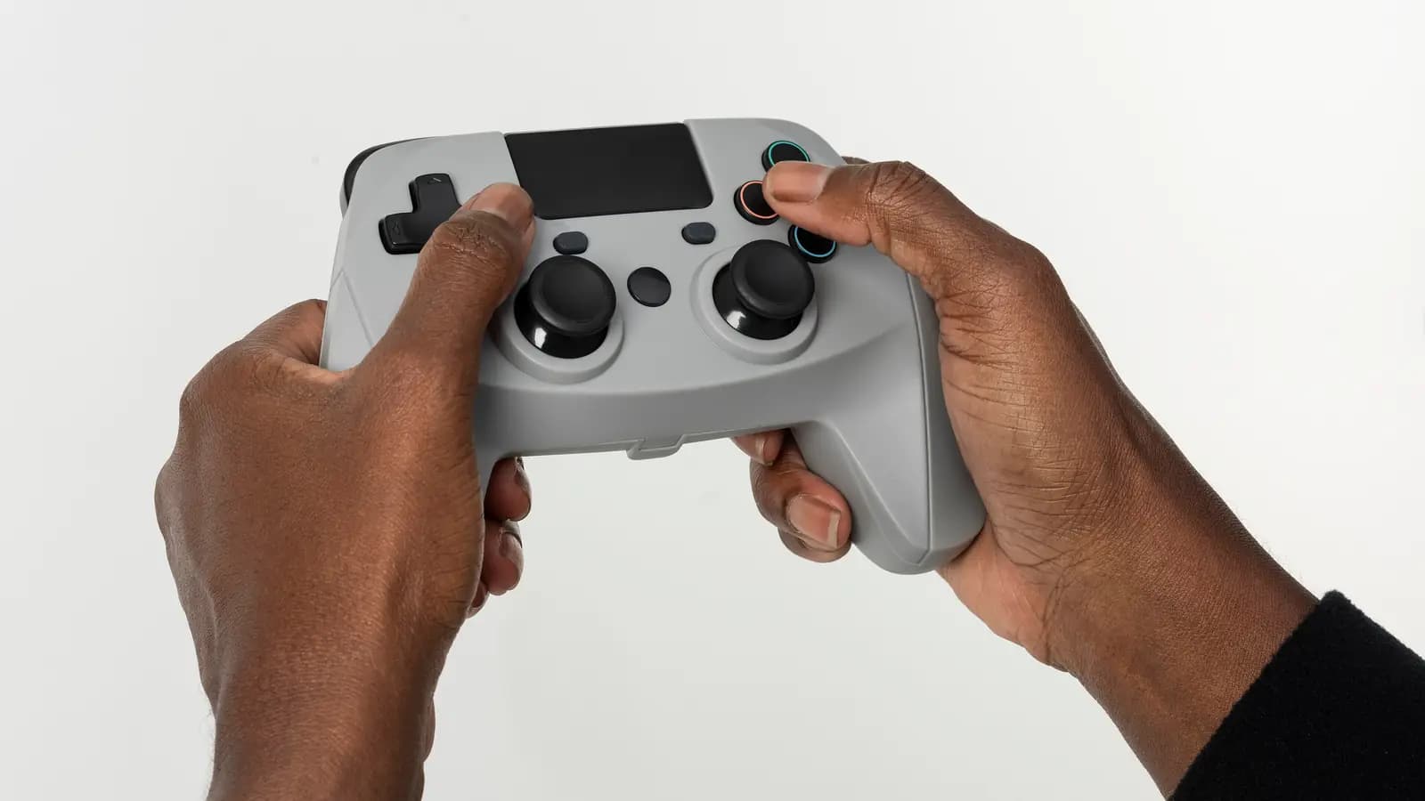 Mãos segurando um controle de videogame cinza sem fio contra um fundo branco